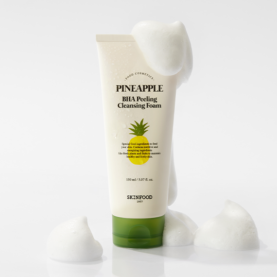 Image of SKINFOOD Pineapple BHA Peeling Cleansing Foam 150ml with foamy bubbles on a white background.