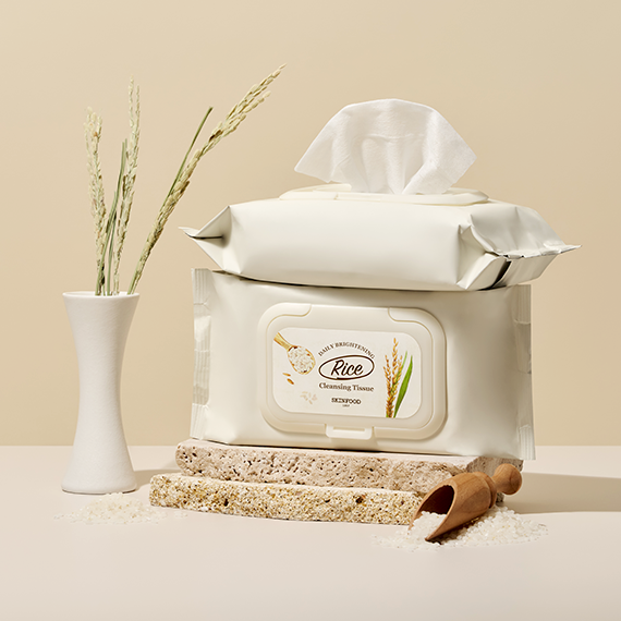 SKINFOOD Rice Daily Brightening Cleansing Tissue 80p with rice extract, shown in a stylish arrangement with rice sprigs and grains.