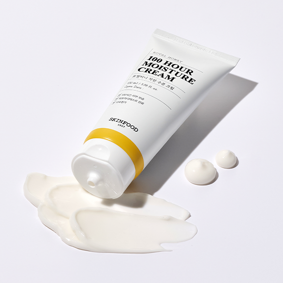 SKINFOOD Royal Honey 100 Hour Moisture Cream 100ml tube with cream spilled on a white background, showcasing product texture and packaging.