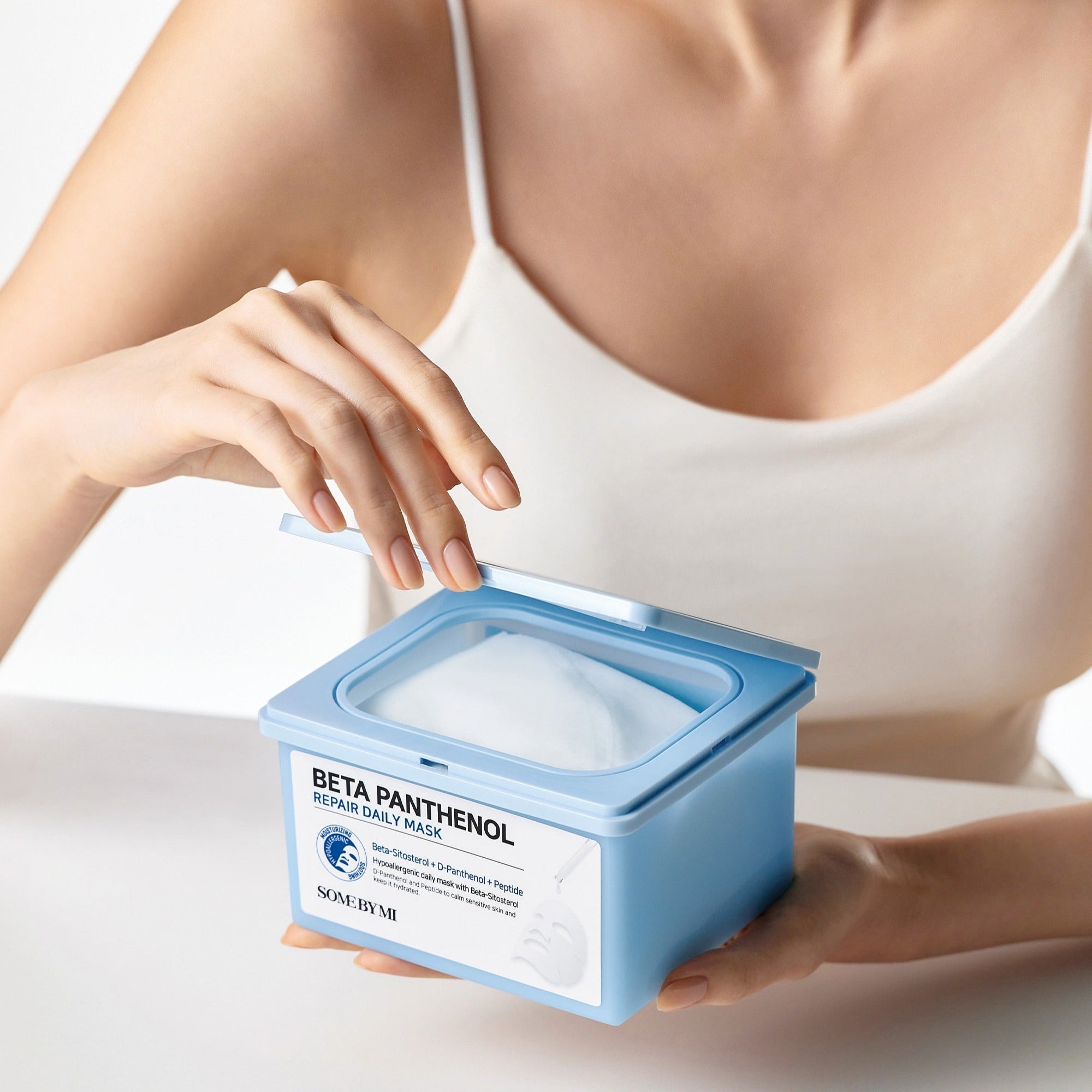 Person using SOME BY MI Beta Panthenol Repair Daily Mask 30ea from a blue container.