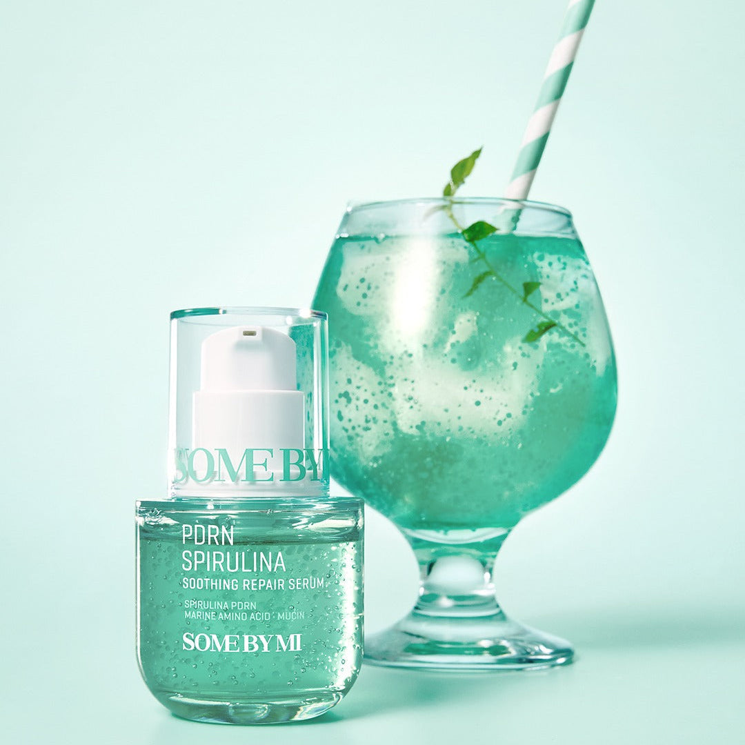 SOME BY MI PDRN Spirulina Soothing Repair Serum 50ml displayed with a green drink in the background.