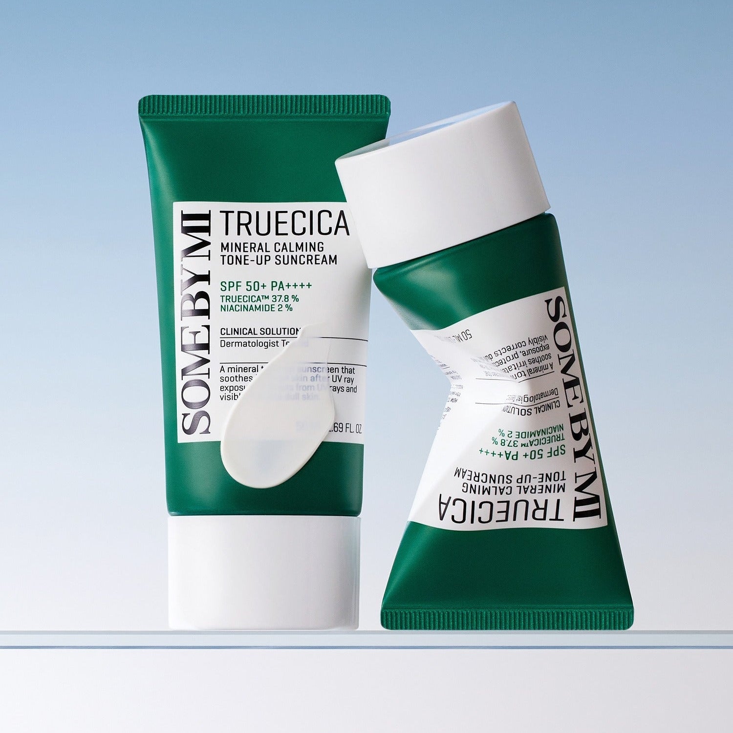 SOME BY MI Truecica Weaponless Calming Tone Up Sun Cream 50ml - green and white tubes displayed against a blue background
