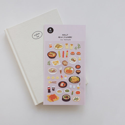 SUATELIER Food Trip #8 Stickers on a white notebook, featuring various food-themed designs.