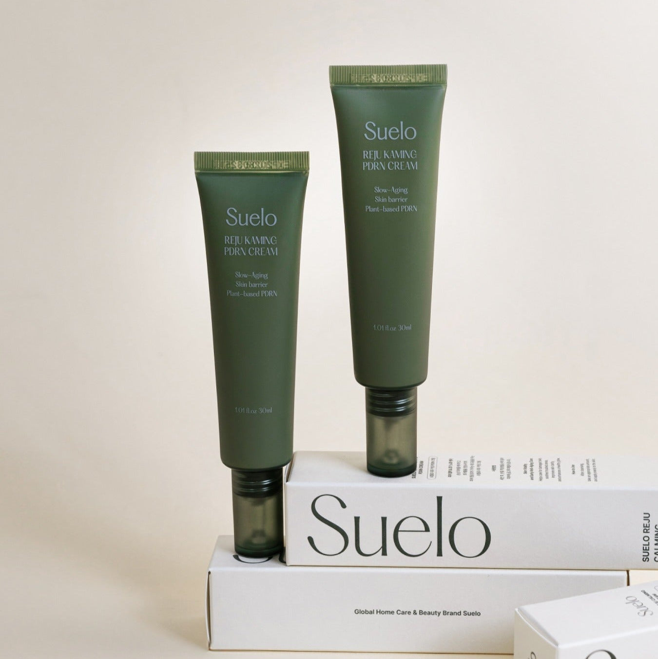 SUELO Reju Calming PDRN Cream 30ml with packaging, skin-soothing formula, two tubes displayed elegantly on beige background