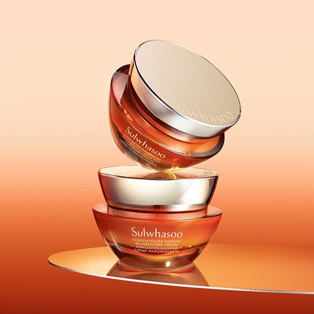SULWHASOO Concentrated Ginseng Rejuvenating Cream in vibrant orange, elegant jars stacked against a matching background.