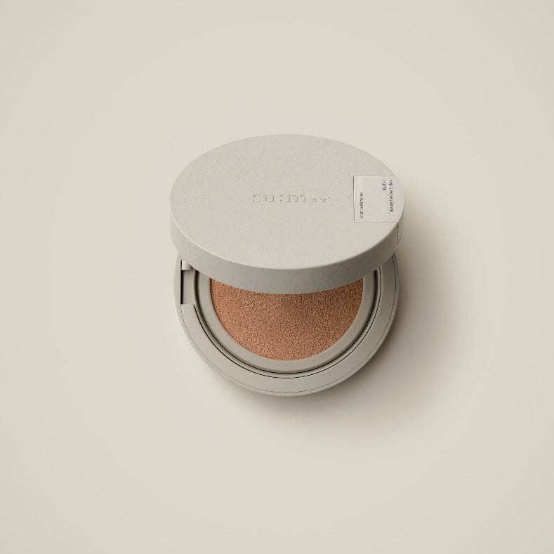 SU:M37 Skin-Stay Soft Glow Cushion in open compact case on soft beige background
