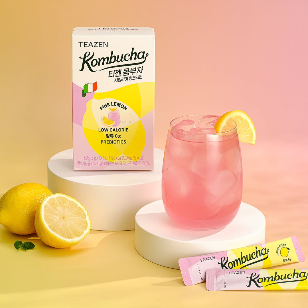 TEAZEN Kombucha Sicillian Pink Lemon 10 Sticks box with two sticks, glass of pink drink with lemon slice, and whole lemon on display.
