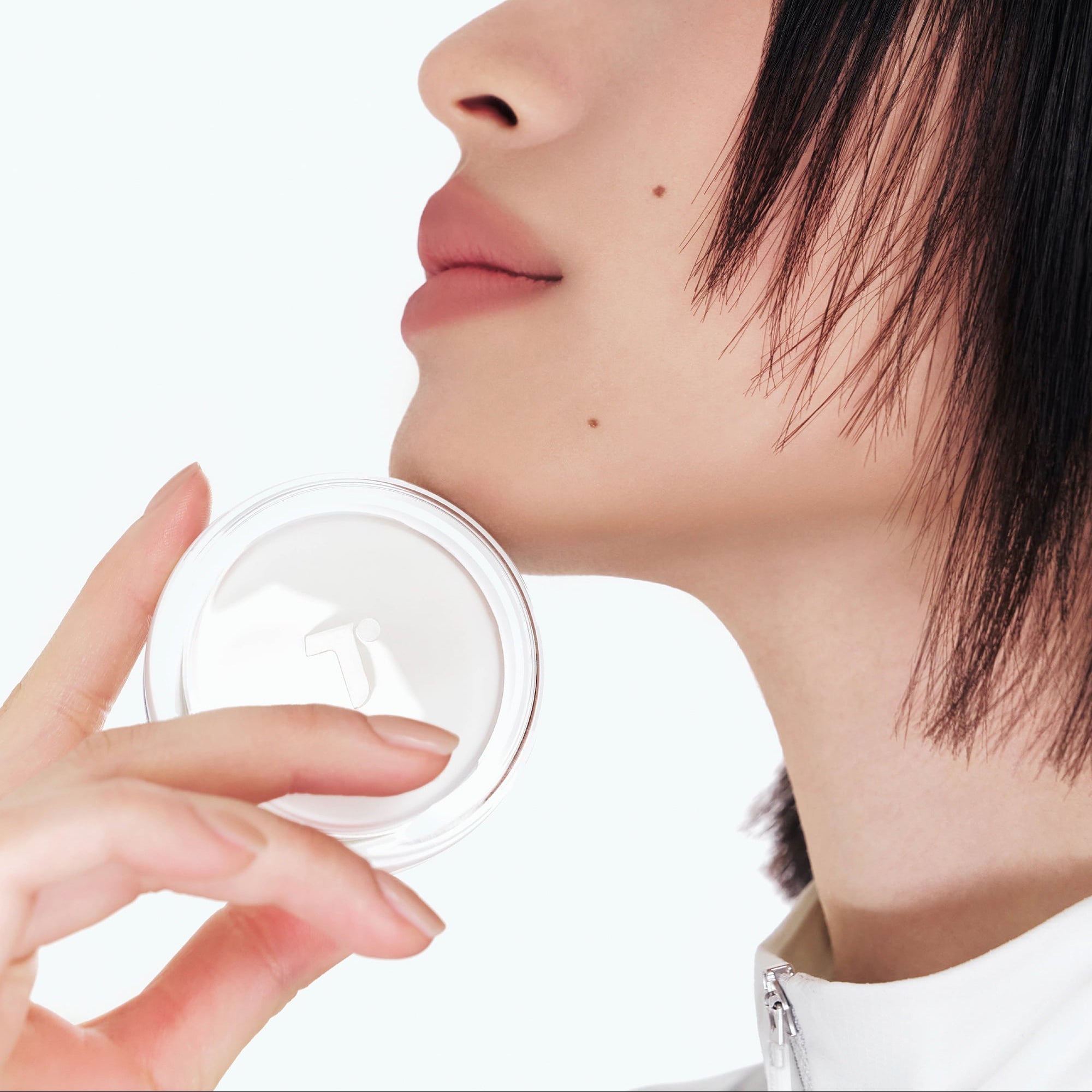 Person holding TENSE Hybrid Makeup Saver near face with close-up profile view.