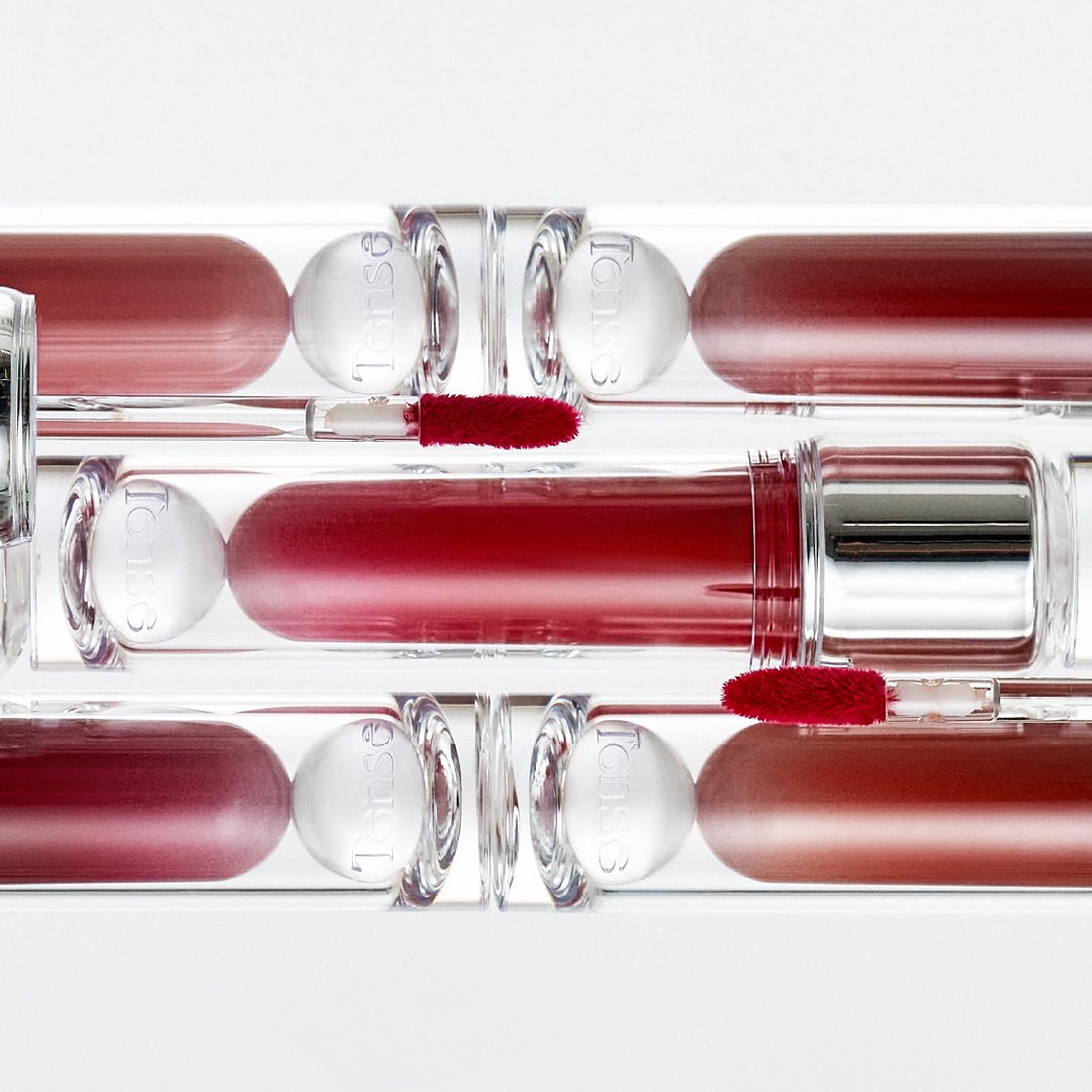 TENSE Shine Moment Glossy Tint in various shades and sleek packaging displayed on a white background.