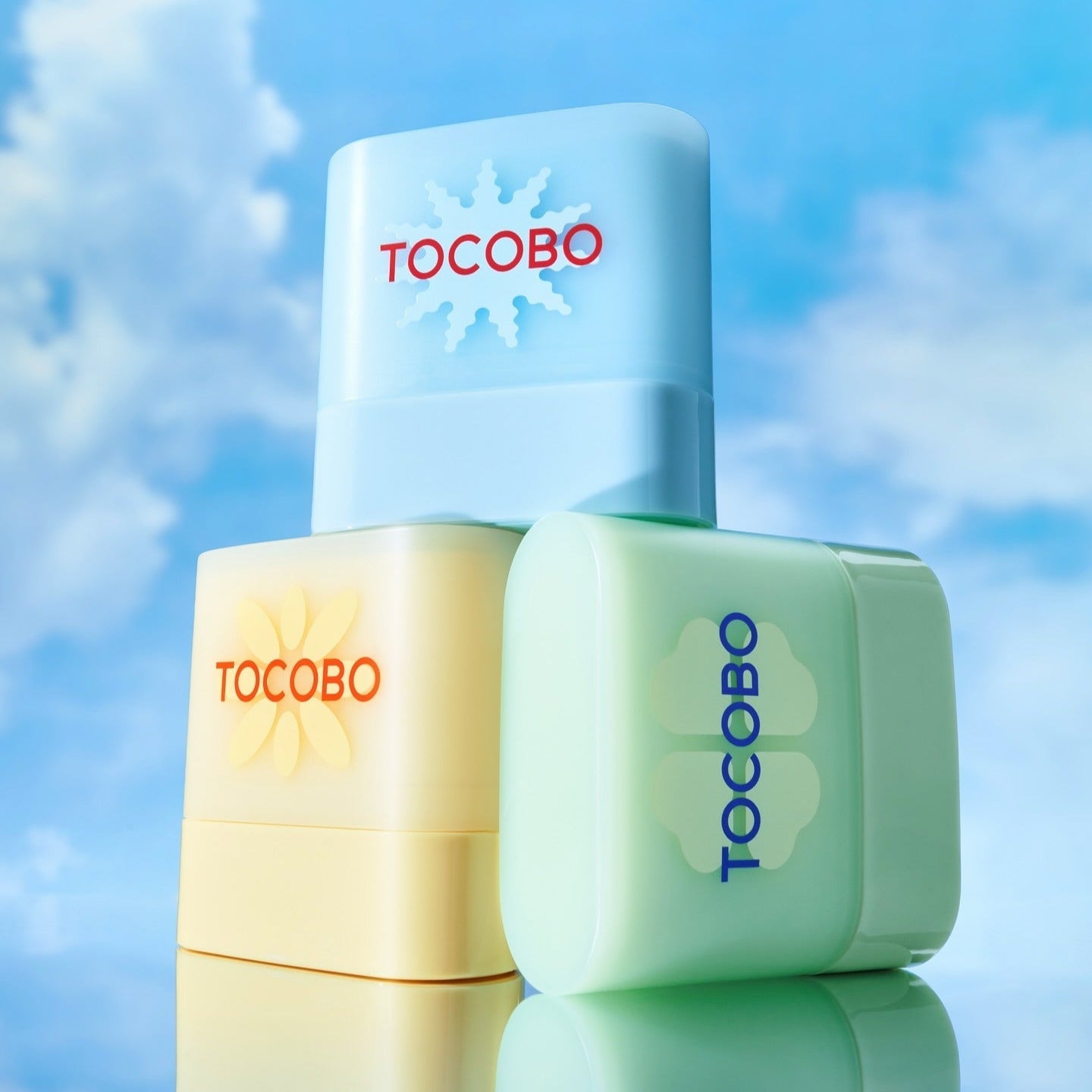 TOCOBO Mini Sun Stick Trio featuring three sunscreen sticks against a blue sky background, perfect for on-the-go sun protection.
