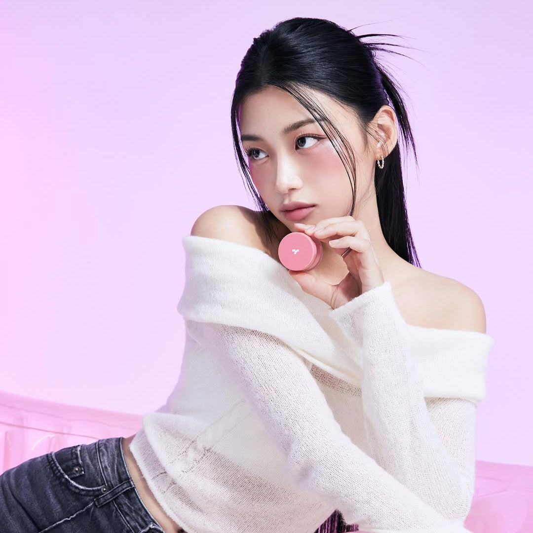 Model holding TONY MOLY Cheek Tone Lip & Cheek Duo Balm against pink background