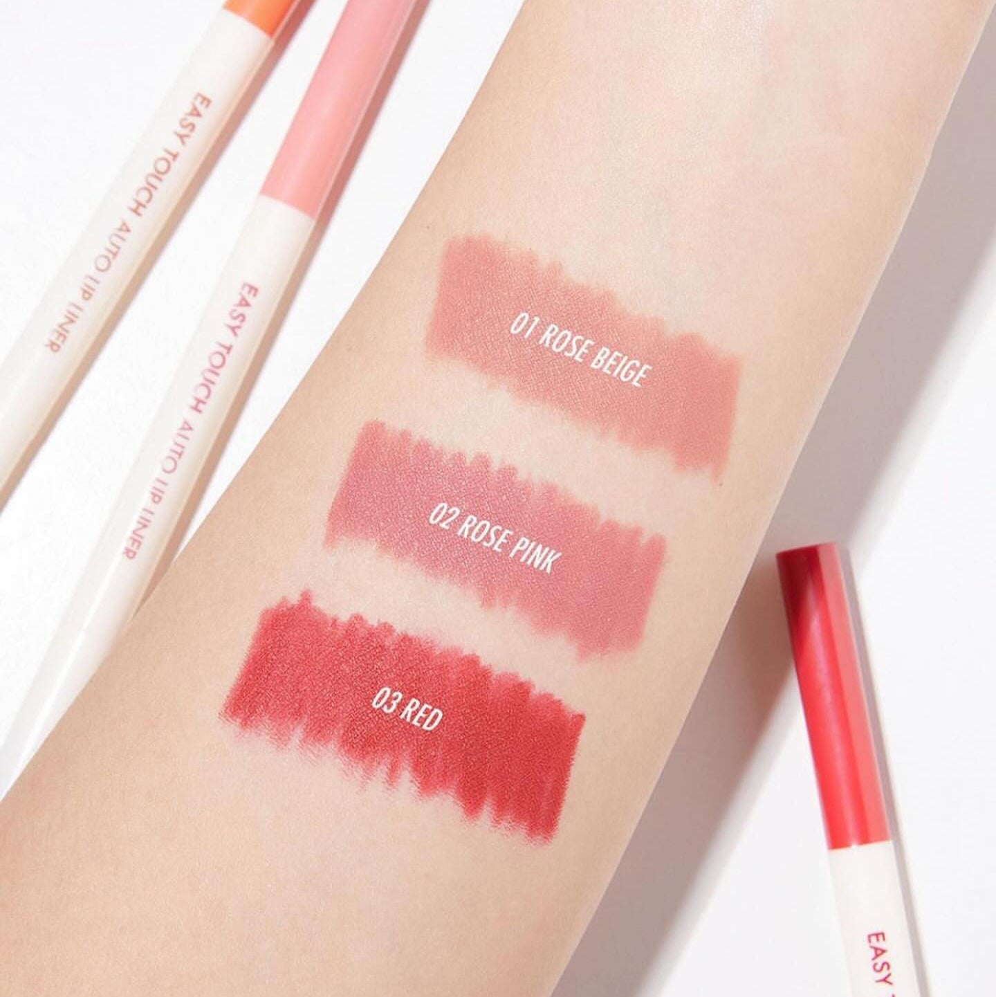 Swatches of TONY MOLY Easy Touch Auto Lip Liner in Rose Beige, Rose Pink, and Red displayed on arm.