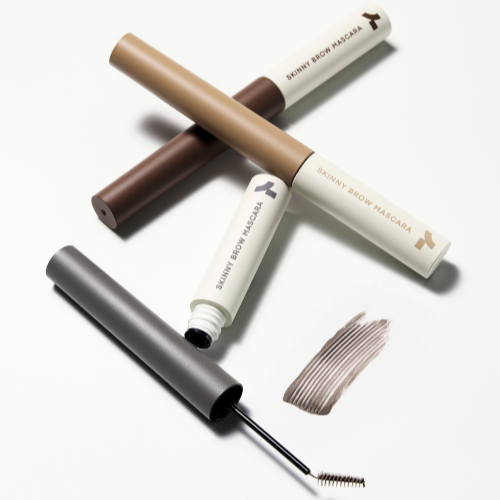 TONY MOLY Eye Tone Skinny Brow Mascara in various shades with brush and color swatch shown on white background.