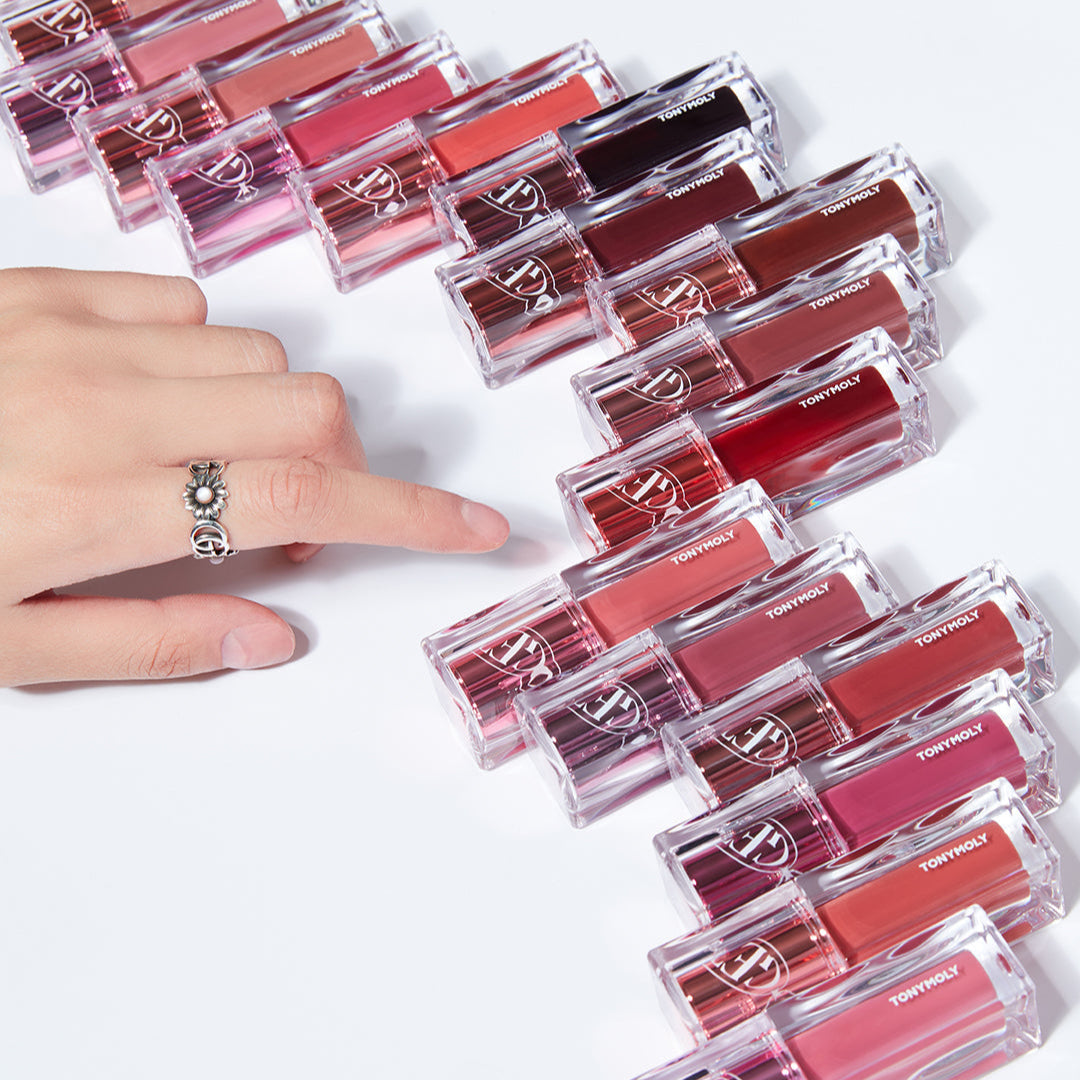 Hand reaching for TONY MOLY Get It Tint Waterful Butter lip colors arranged in a row