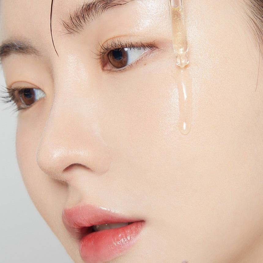 Close-up of person applying TONYMOLY 2X Vitamin C Toning Ampoule 50ml to skin, highlighting its brightening effect.
