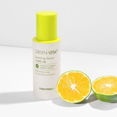 Bottle of TONYMOLY Green Vita C Sparkling Serum 55ml with sliced citrus fruits on a white background.