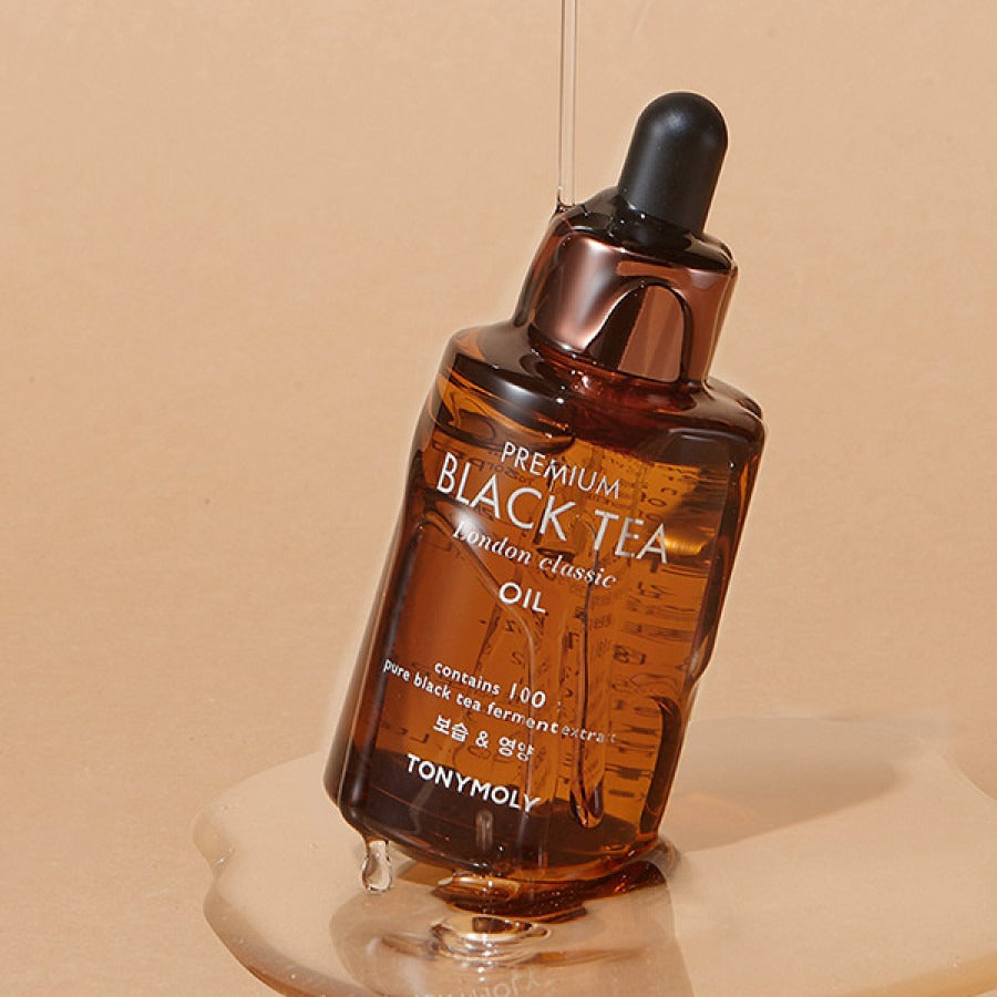 TONYMOLY Premium Black Tea London Classic Oil 35ml bottle with dropper and text visible on a beige background.