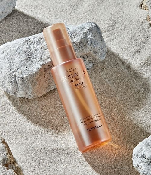 TONYMOLY Triple Collagen Total Tension Mist 110ml bottle placed on sandy background surrounded by rocks.