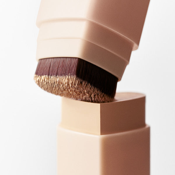 TOUCH IN SOL Pretty Filter In My Heart Stick Foundation with close-up of brush applicator and creamy texture detail.