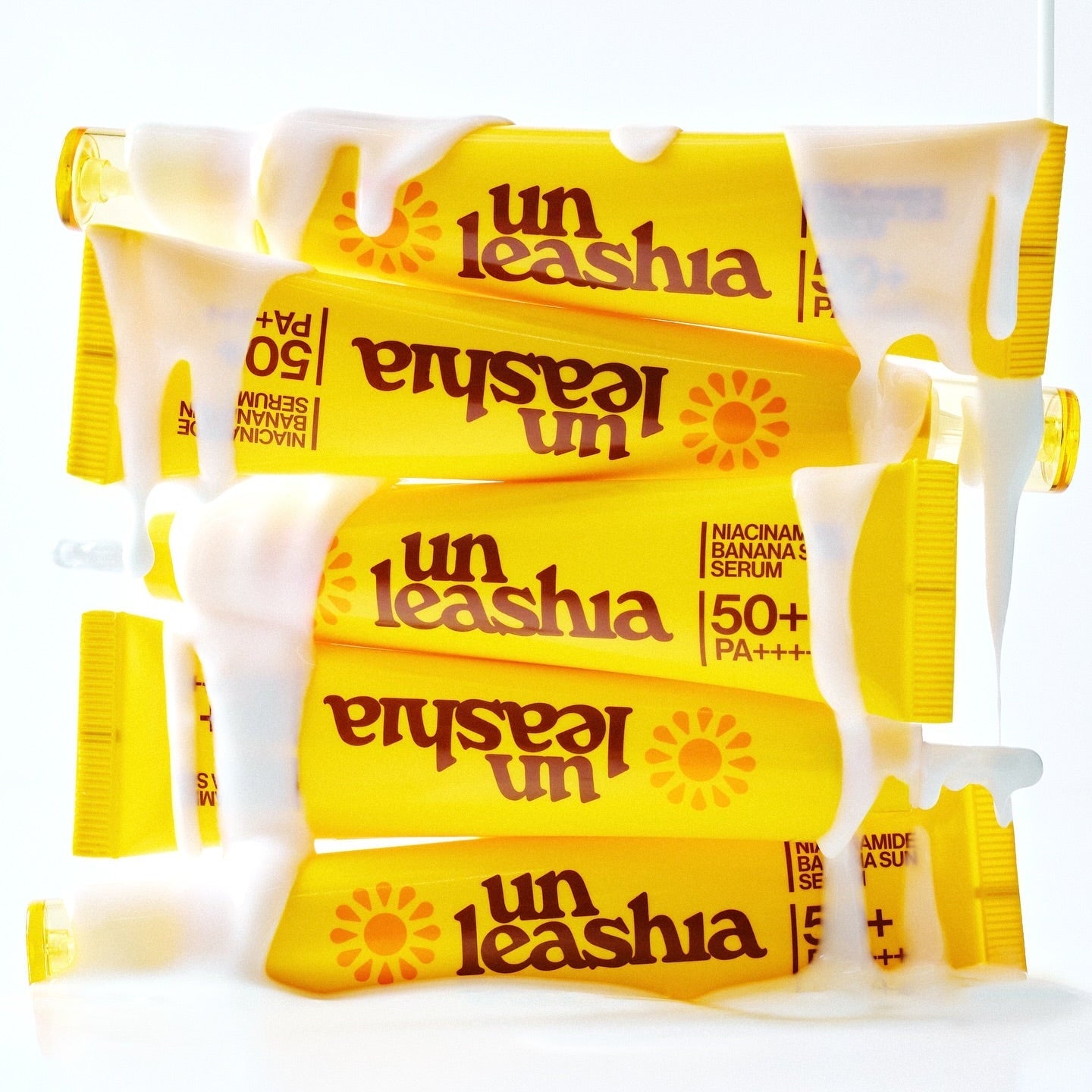 UNLEASHIA Niacinamide Banana Sun Serum 40ml tubes stacked with cream covering them.