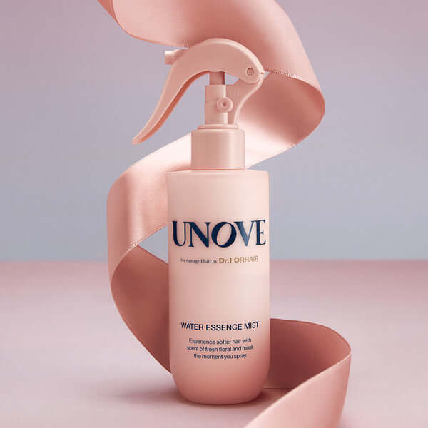 UNOVE Water Essence Mist 200ml bottle on pink background with ribbon, enhancing hair softness and natural scent.