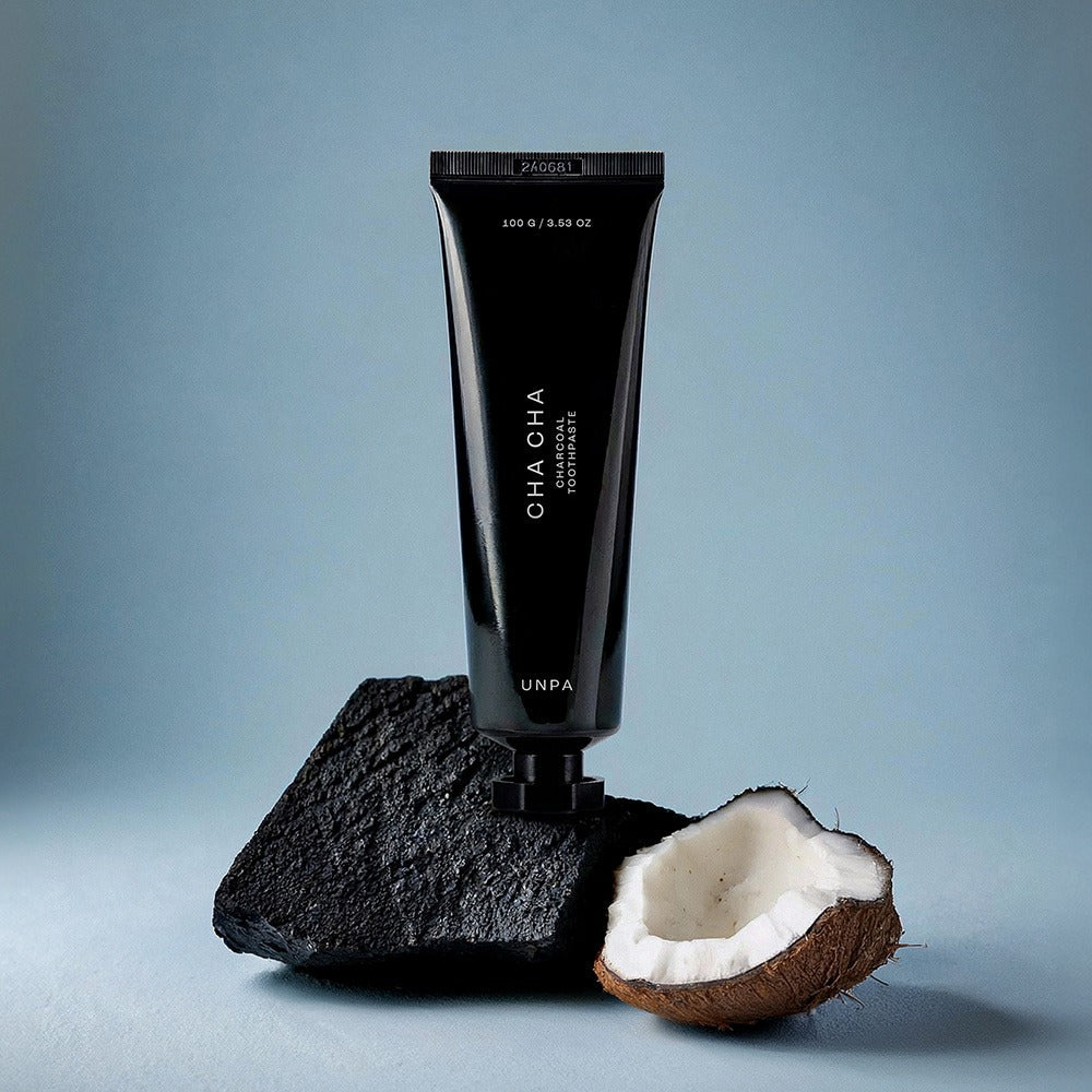 UNPA Cha Cha Charcoal Original Toothpaste 100g tube with charcoal and coconut on blue background