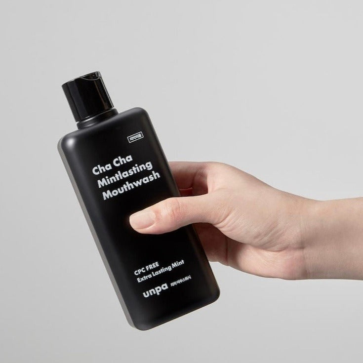 Hand holding a bottle of UNPA Cha Cha Mintlasting Mouthwash 300ml, showing the product label for fresh oral care.