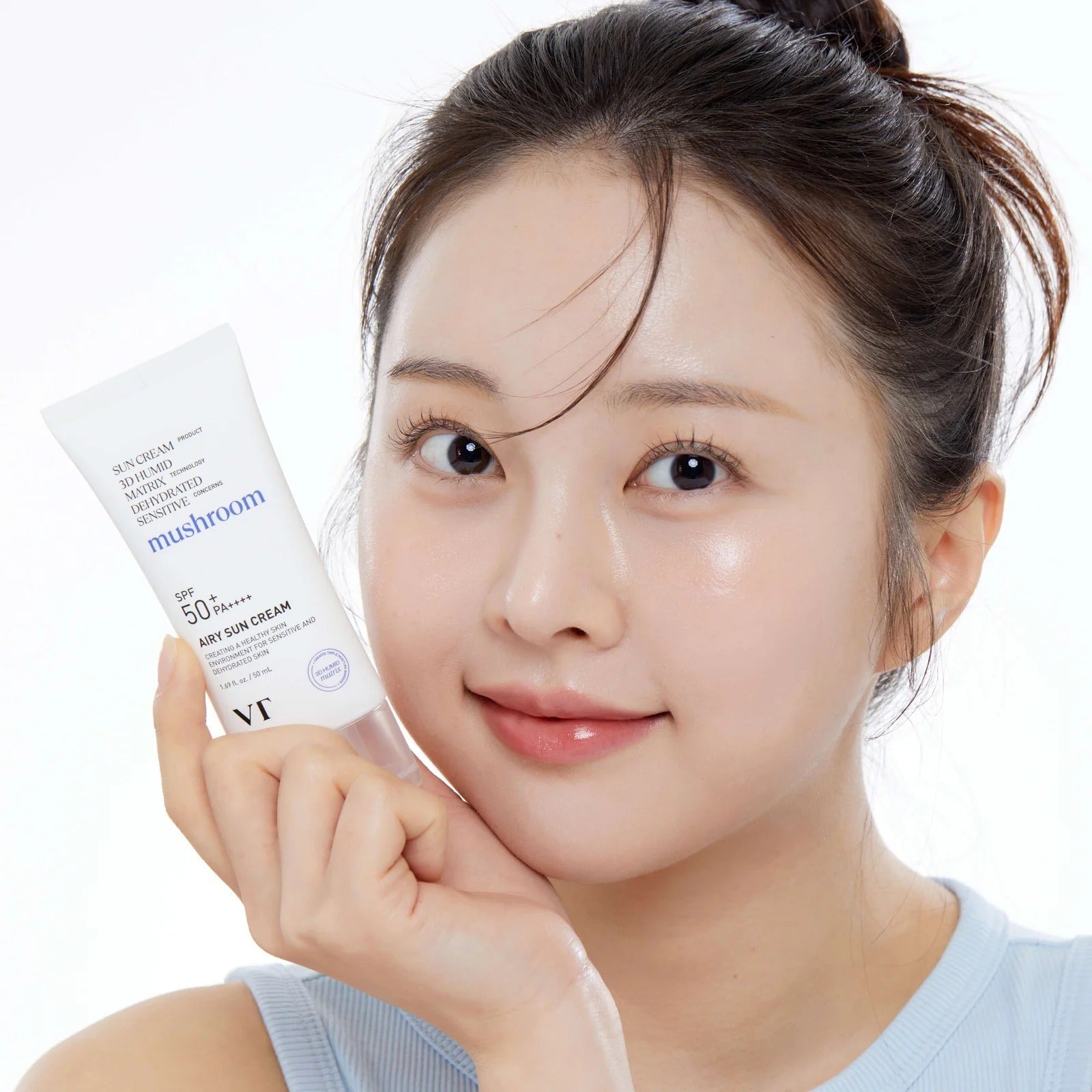 Smiling person holding VT COSMETIC Airy Sunscreen 50ml product tube close-up.