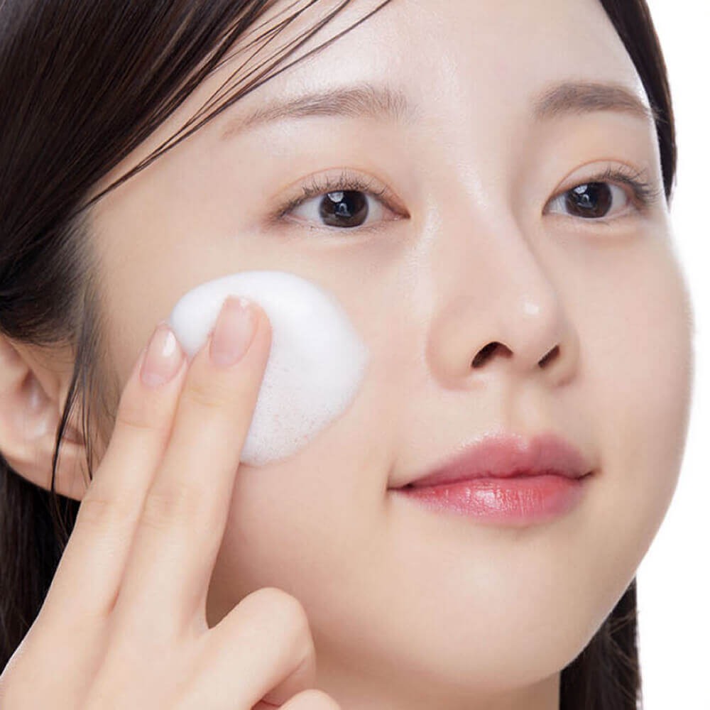 Woman applying VT COSMETIC PDRN Hyaluronic Acid Mint Micro Bubble Serum 70ml to her face for skincare routine