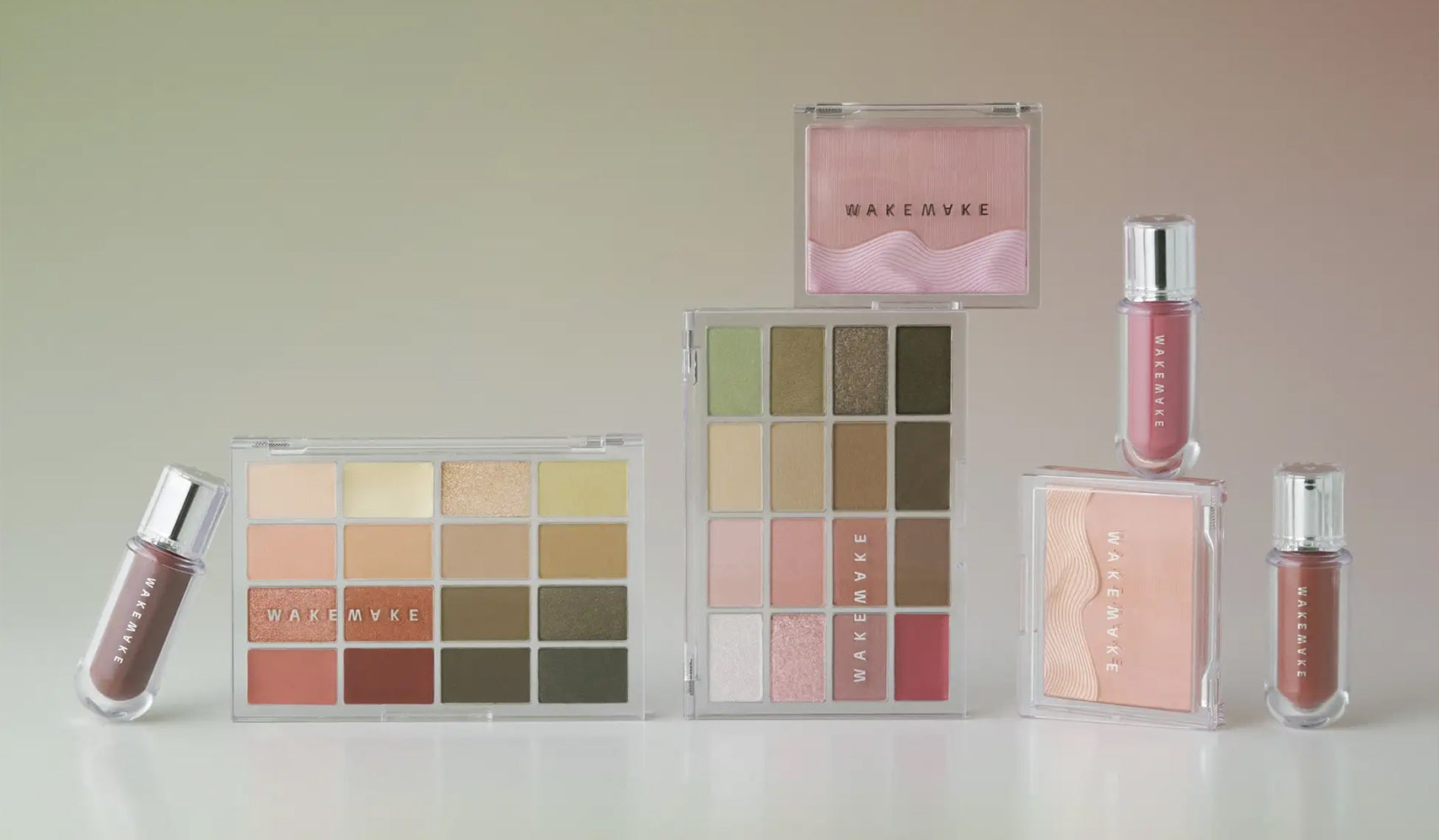 Assorted makeup palettes and lip glosses on display with neutral and pink shades