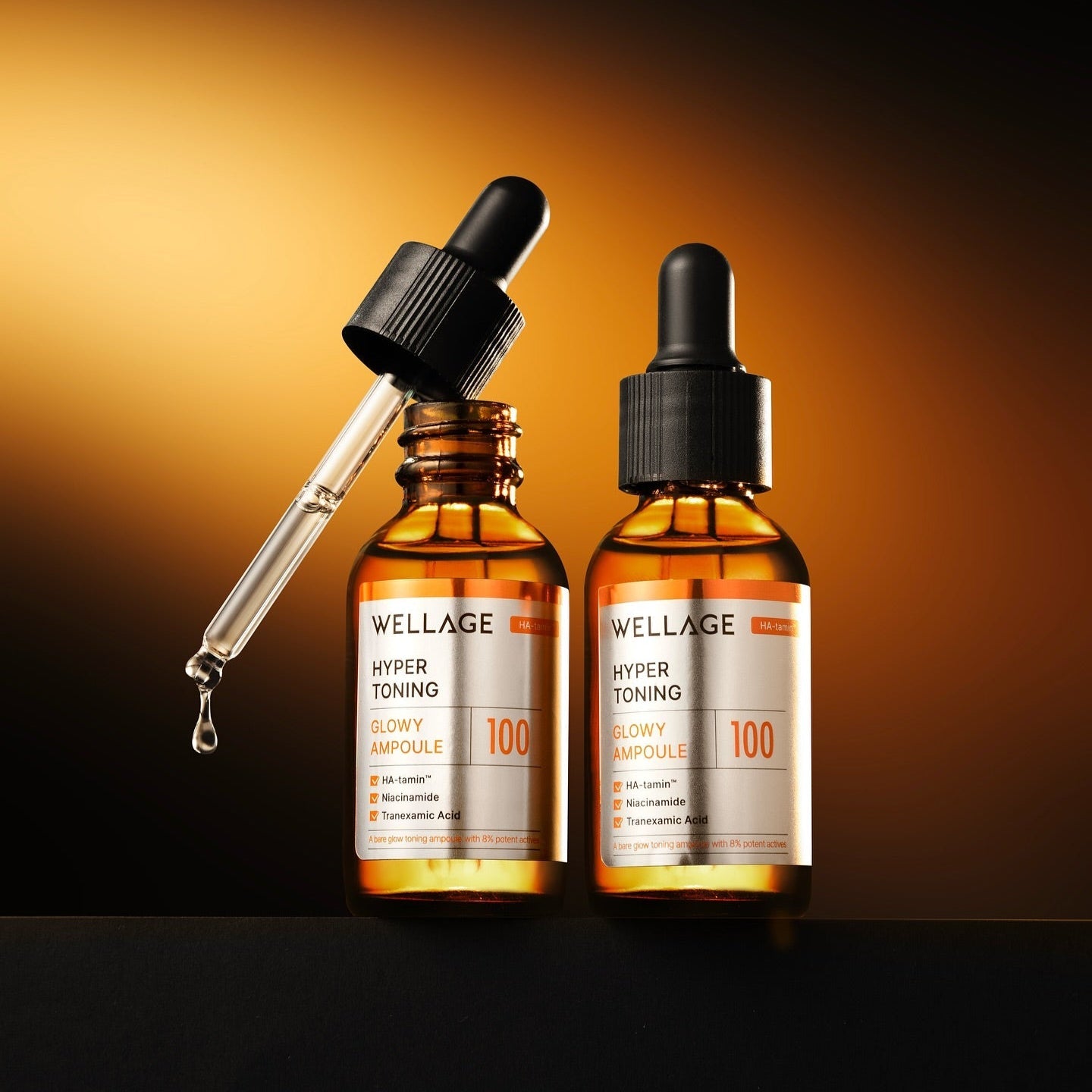 Two bottles of WELLAGE Hyper Toning Glow Ampoule 30ml with a dropper on a dark background.