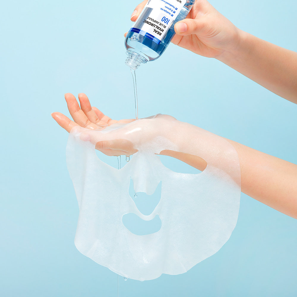 WELLAGE Real Hyaluronic Blue Ampoule Mask 5 Sheets being prepared for use on a hand with a light blue background.