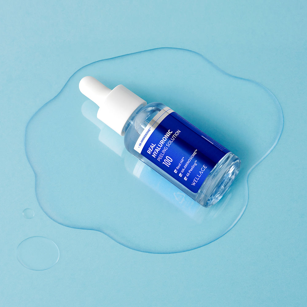 WELLAGE Real Hyaluronic Peeling Solution 30ml serum bottle on a blue background with liquid drops.