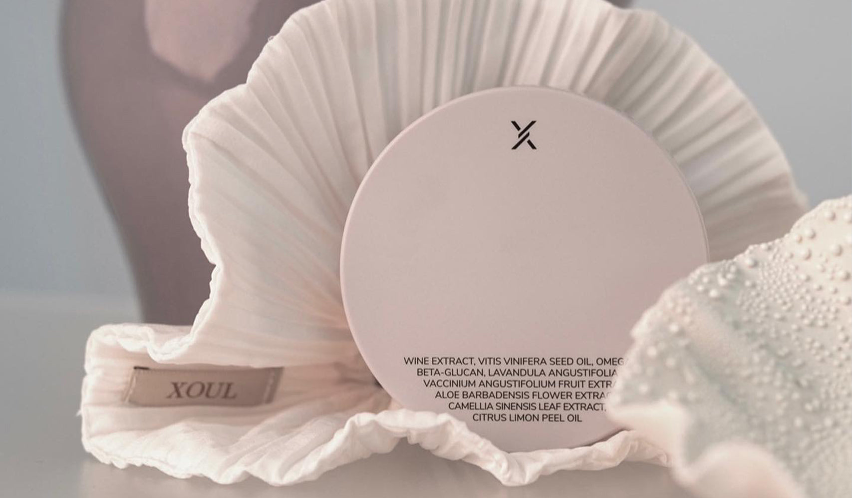XOUL skincare product displayed on a decorative white fabric background