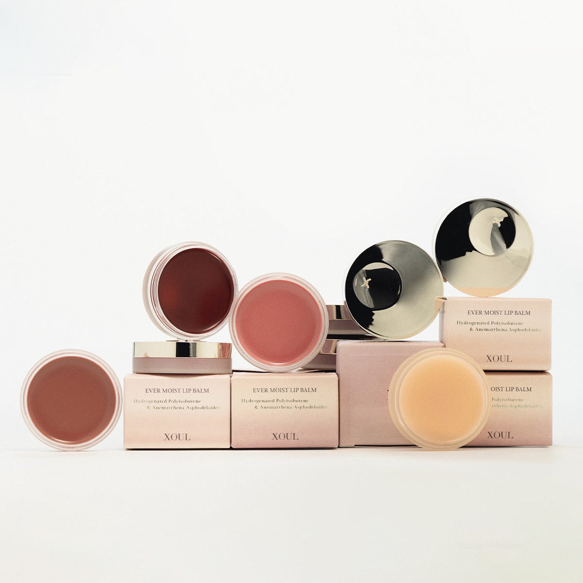 XOUL Ever Moist Volume Lip Balm 8g - Variety of lip balms in containers with pink boxes, showcasing different shades and packaging.