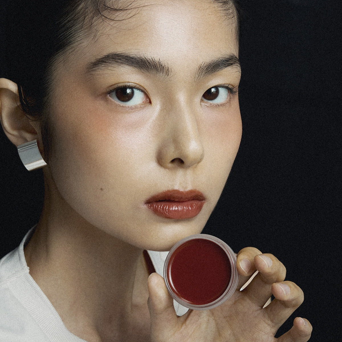 Close-up of a person holding XOUL Ever Moist Volume Lip Balm 8g, showcasing its color and texture.