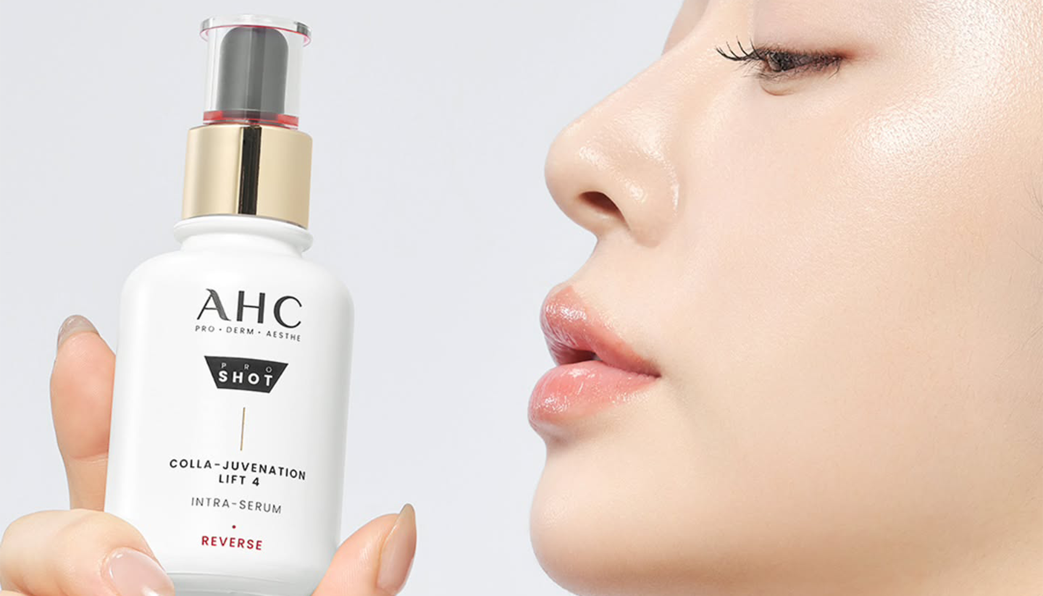 AHC Colla-Rejuvenation Lift Intra-Serum bottle held next to a woman's clear skin, showcasing its hydrating and smoothing effects.