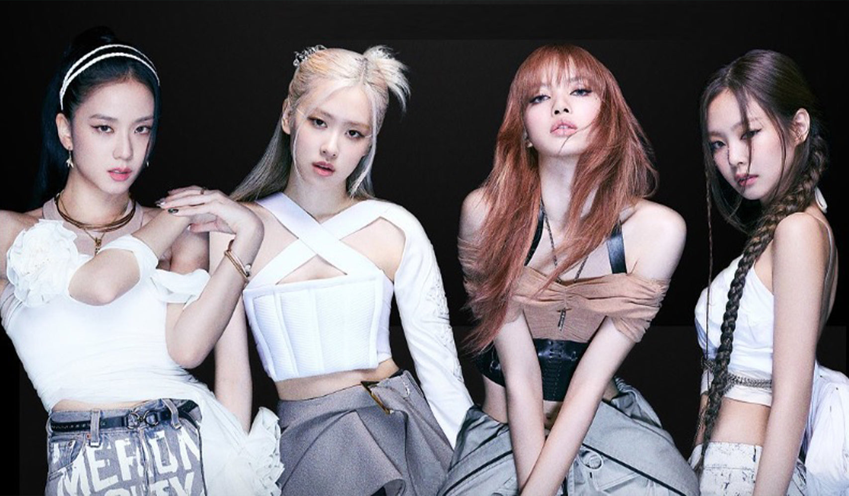Four women posing in stylish black and white fashion outfits against a dark background.