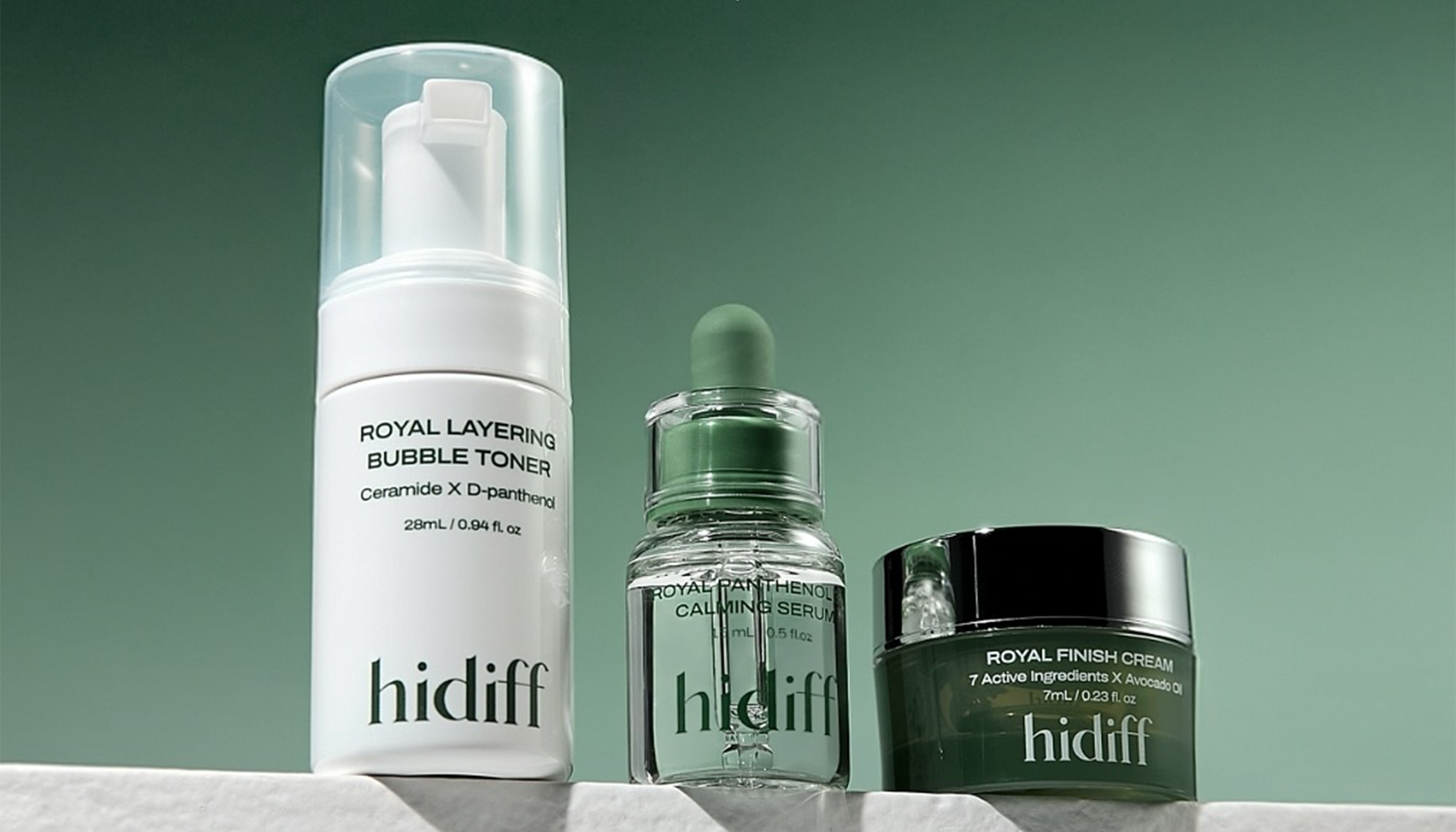 Hidiff skincare products including Royal Layering Bubble Toner, Calming Serum, and Royal Finish Cream on a green background.