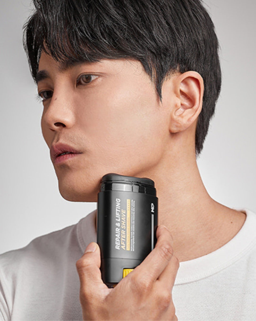Person using repair and lifting aftershave stick on face for skincare routine